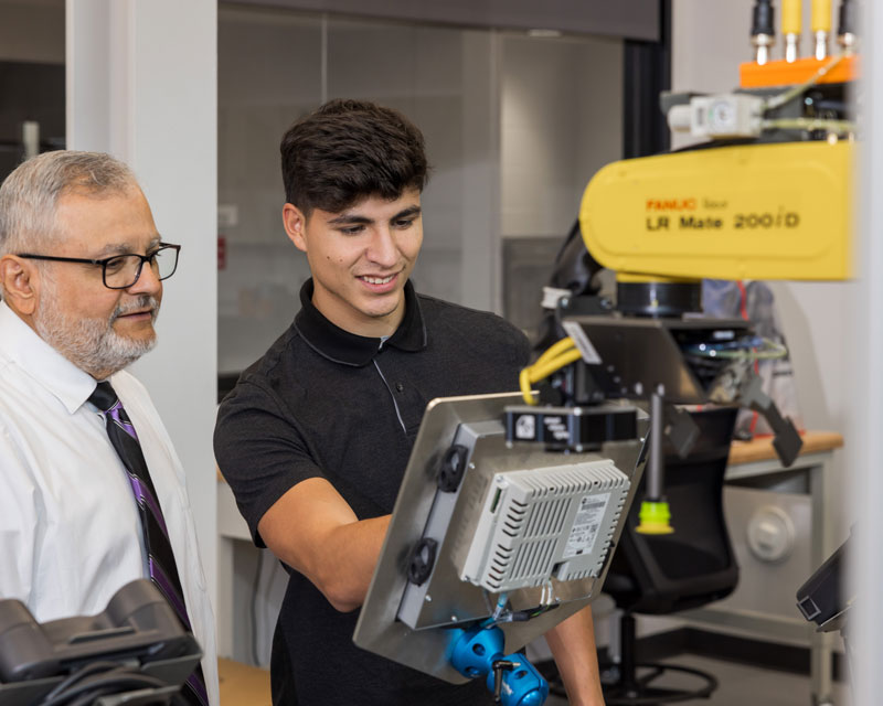 Dr. Maximo Ortega training a student on a robot